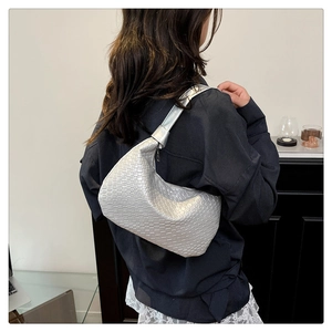 Silver woven texture hobo bag detail showing metallic finish on model's shoulder