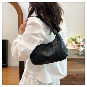Detailed close-up of a black woven hobo bag showing the high-quality lattice texture