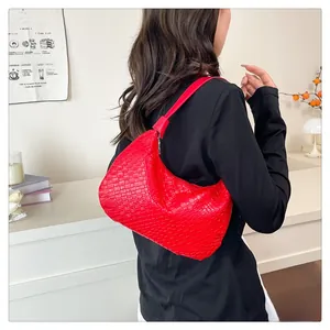 Detail of red woven texture on a minimalist large capacity semi-circle PU shoulder bag