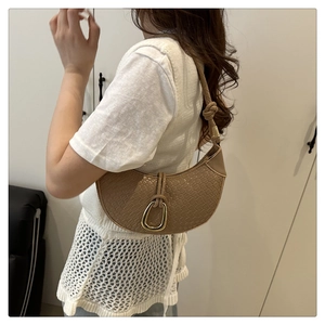 Brown crocodile embossed hobo bag with knotted strap and gold buckle on a model