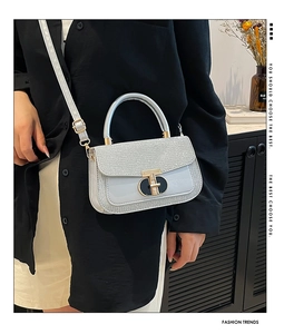 Detail of light blue sequin handbag with gold hardware and stylish top handle design