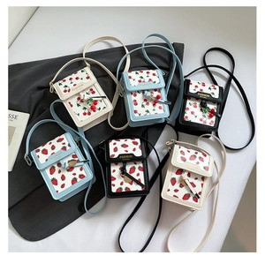 Detailed top view of mini shoulder bags in blue, white, and black with fruit prints