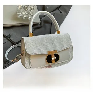 Detail showing silver woven texture and gold T-shaped clasp on elegant handbag