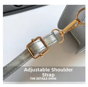 Adjustable grey leather shoulder strap with shiny gold metal buckle and precision stitching