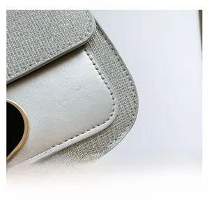 Detailed macro view of silver sequin fabric and matte texture leather stitching on handbag