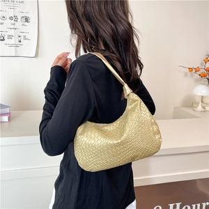 Metallic gold crocodile pattern shoulder bag with a half-moon shape on a model