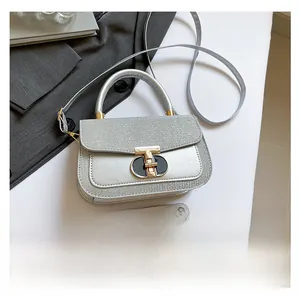 Silver sequin handbag size comparison with a smartphone showing compact square dimensions