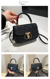 Detail of black sequined handbag featuring a golden T-shaped twist lock and top handle