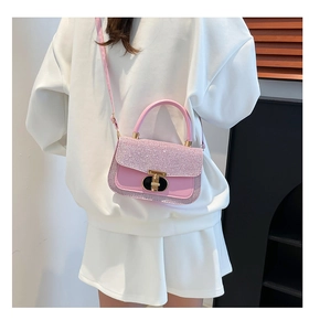 Side view of pink sequined crossbody bag worn by a model in casual white outfit