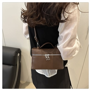 Detail of coffee litchi grain leather mini bag with silver zippers and shoulder strap
