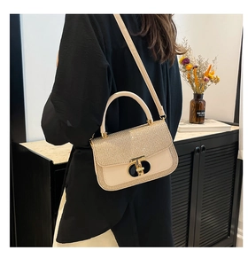 Chic beige crossbody bag with sparkling flap and gold T-lock shown in lifestyle setting