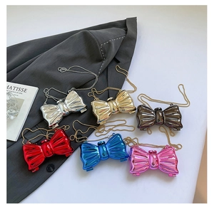 Detailed display of butterfly mini chain bags in six metallic colors on a chic suit background