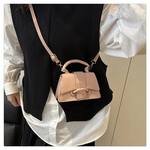 Detail of pink lychee leather mini crossbody bag with gold hardware and shoulder strap