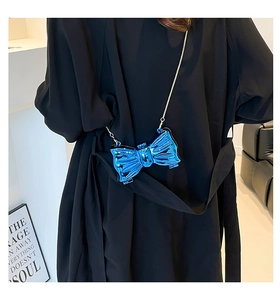 Close-up of metallic blue butterfly-shaped evening clutch bag with golden chain strap