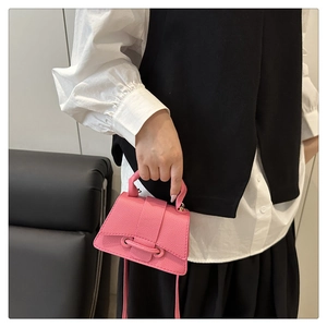 Detailed close-up of pink mini handbag showing pebble grain leather texture and strap