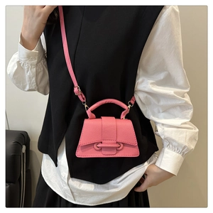 Detail of rose pink mini bag featuring lychee texture and buckle on a crossbody model