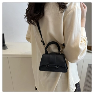 Rear view of a model wearing a mini black leather crossbody bag with lychee texture