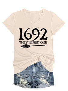 Close-up of beige V-neck T-shirt with 1692 they missed one text and broom graphic