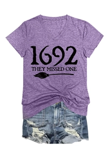 Detail of purple V-neck T-shirt with 1692 lettering and denim shorts flat lay