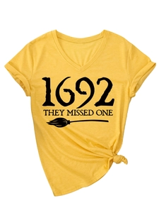 Detail of V-neck mustard t-shirt with 1692 text, witch broom print and front knot design