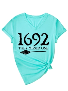 Detail of V-neck mint green T-shirt with 1692 they missed one witch graphic and rolled sleeves