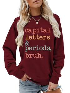 Detail of burgundy sweatshirt featuring a colorful vintage slogan and soft cotton texture