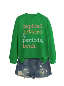 Flat lay of a green crewneck sweatshirt with vintage graphic text and denim shorts