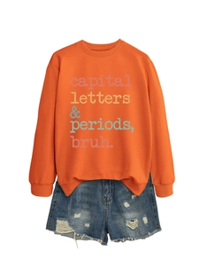 Detail of orange sweatshirt with letters and distressed blue denim shorts set