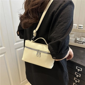 Beige lychee leather crossbody bucket bag with dual zippers and adjustable shoulder strap