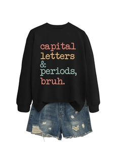 Flat lay of black crewneck sweatshirt with vintage lettering and ripped denim shorts