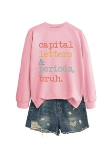 Detail of pink sweatshirt with slogan print and distressed denim shorts outfit set