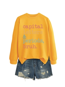 Detail of yellow sweatshirt with letter print and distressed denim shorts with frayed edges