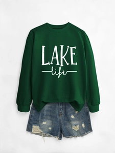 Detail of dark green Lake Life sweatshirt paired with distressed blue denim shorts