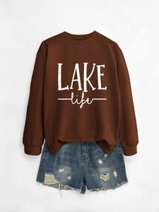 Detail of loose Lake Life lettering printed on a dark brown crewneck sweatshirt fabric