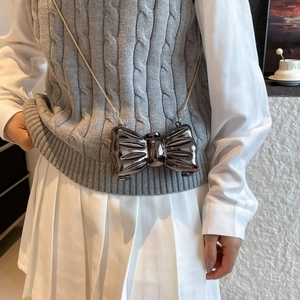 Mini acrylic bow bag in glossy metallic dark grey finish with a thin gold chain strap