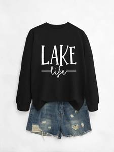 Detail view of black crewneck sweatshirt with LAKE life text and distressed denim shorts