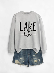 Close-up of gray LAKE life sweatshirt paired with distressed blue denim shorts