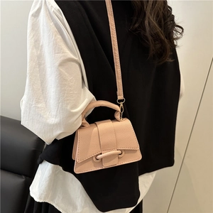 Pink textured leather trapezoid handbag with top handle and shoulder strap on model