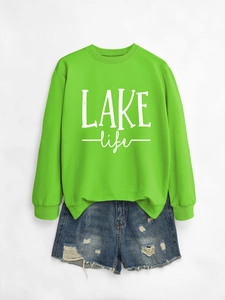 Detail of neon green crewneck sweatshirt with LAKE life text and denim shorts