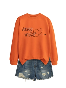 Detail of orange Vacay Mode sweatshirt with ribbed cuffs and distressed denim shorts
