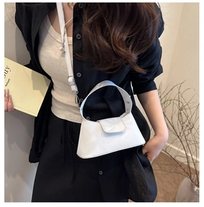 Détail d'un sac à main blanc minimaliste avec rabat et bandoulière fine pour femmes