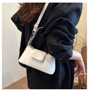 Detailed view of a white leather crossbody bag with FANYISSA embossed logo on flap