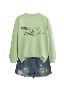 Detail of light green vacay mode sweatshirt with heart plane print and denim shorts