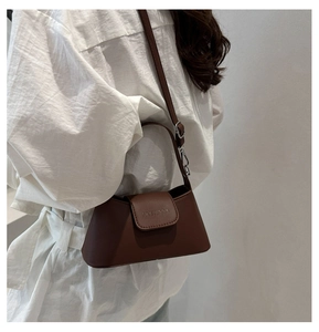 Vue latérale du sac trapèze en cuir marron foncé avec bandoulière sur un mannequin