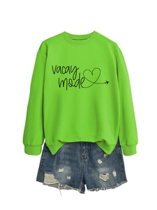 Detail of neon green vacay mode sweatshirt with heart print and distressed denim shorts