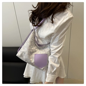 Detail of hobo bag featuring geometric jacquard fabric and purple faux leather side pocket