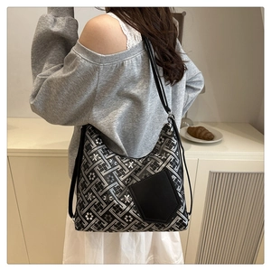 Détail du sac cabas à motifs géométriques avec bandoulière en cuir porté par un mannequin