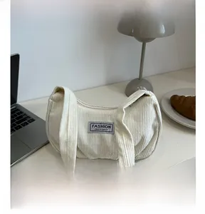 Detail of cream corduroy moon bag featuring a Fashion Instinct label and striped texture