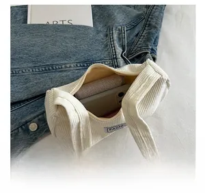 Interior view showing the large capacity of a white corduroy shoulder bag with essentials