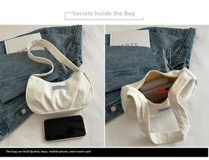 Detail showing white corduroy shoulder bag with inner compartment and phone capacity view